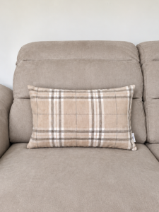 Beżowa sofa z poduszką w kratę.png