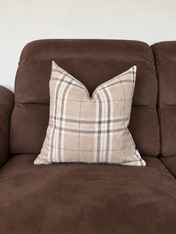 Czekoladowa sofa z kraciastą poduszką.png